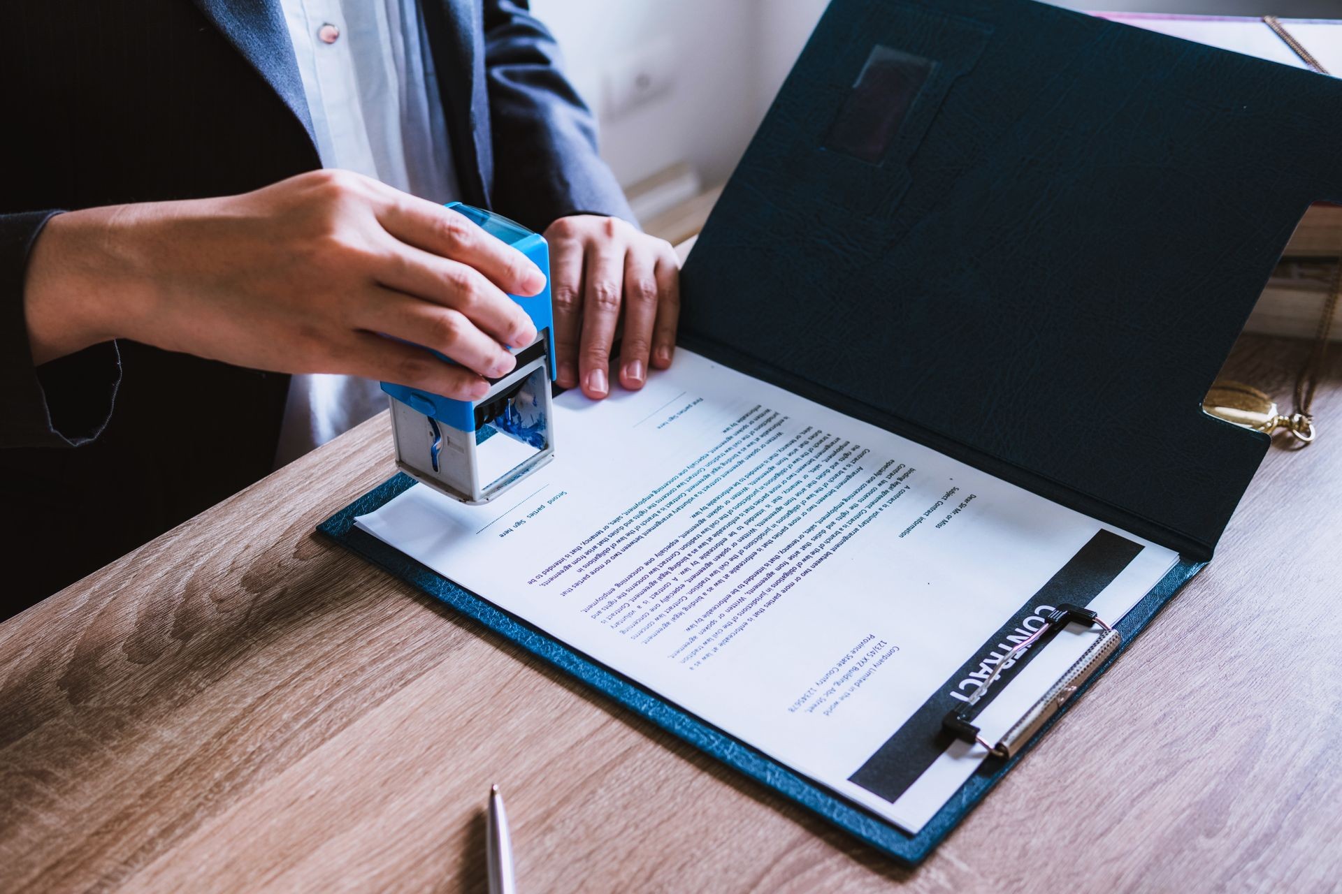 Business woman sitting with brass scale at lawyer desk, Lawyer working hand holding automatic stamp important documents in office. lawyer and law ,judiciary and legislature courtroom legal concept.